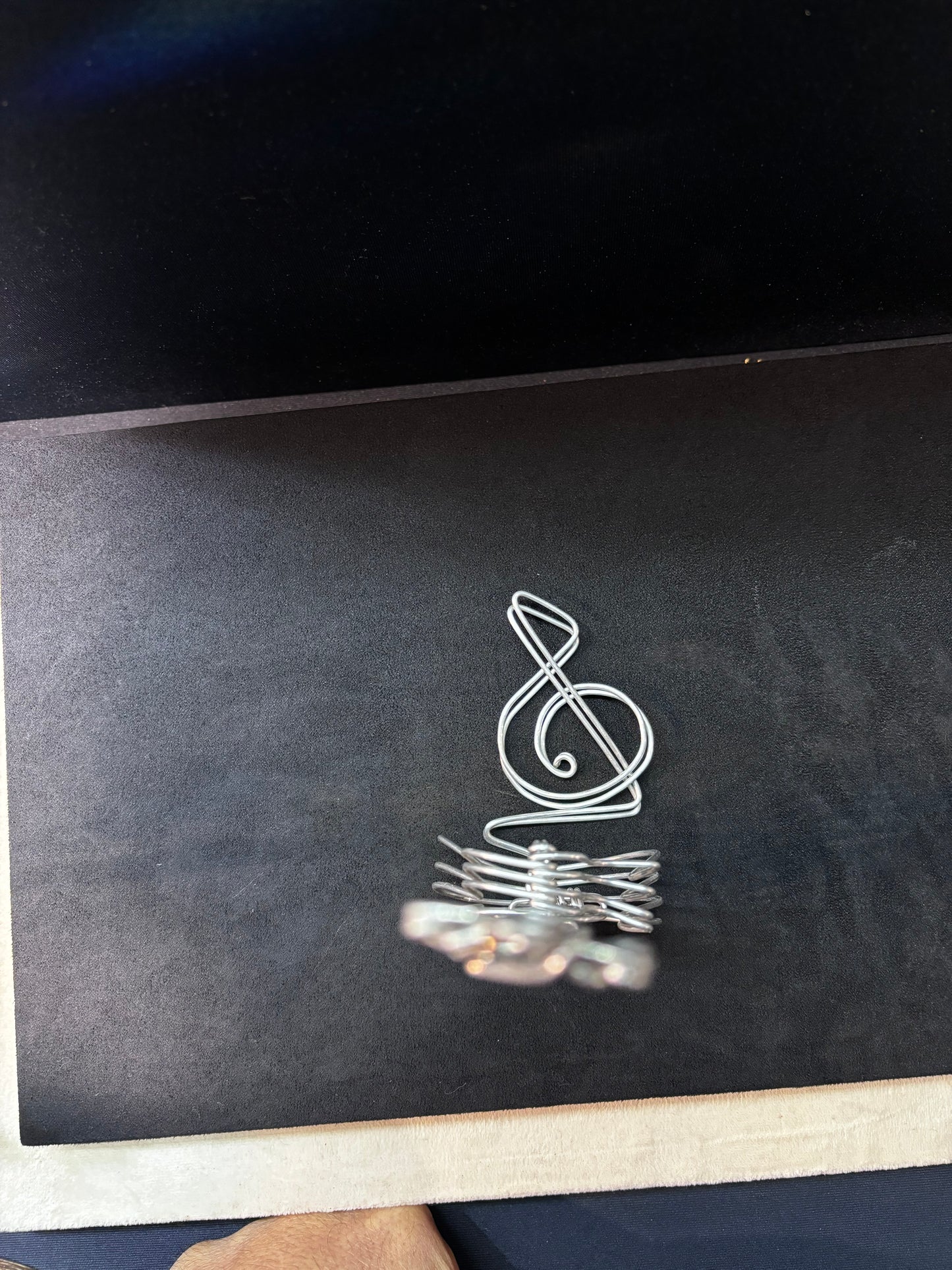 Petit accessoire en aluminium représentant une clé de sol musicale, assorti à la sculpture de guitare