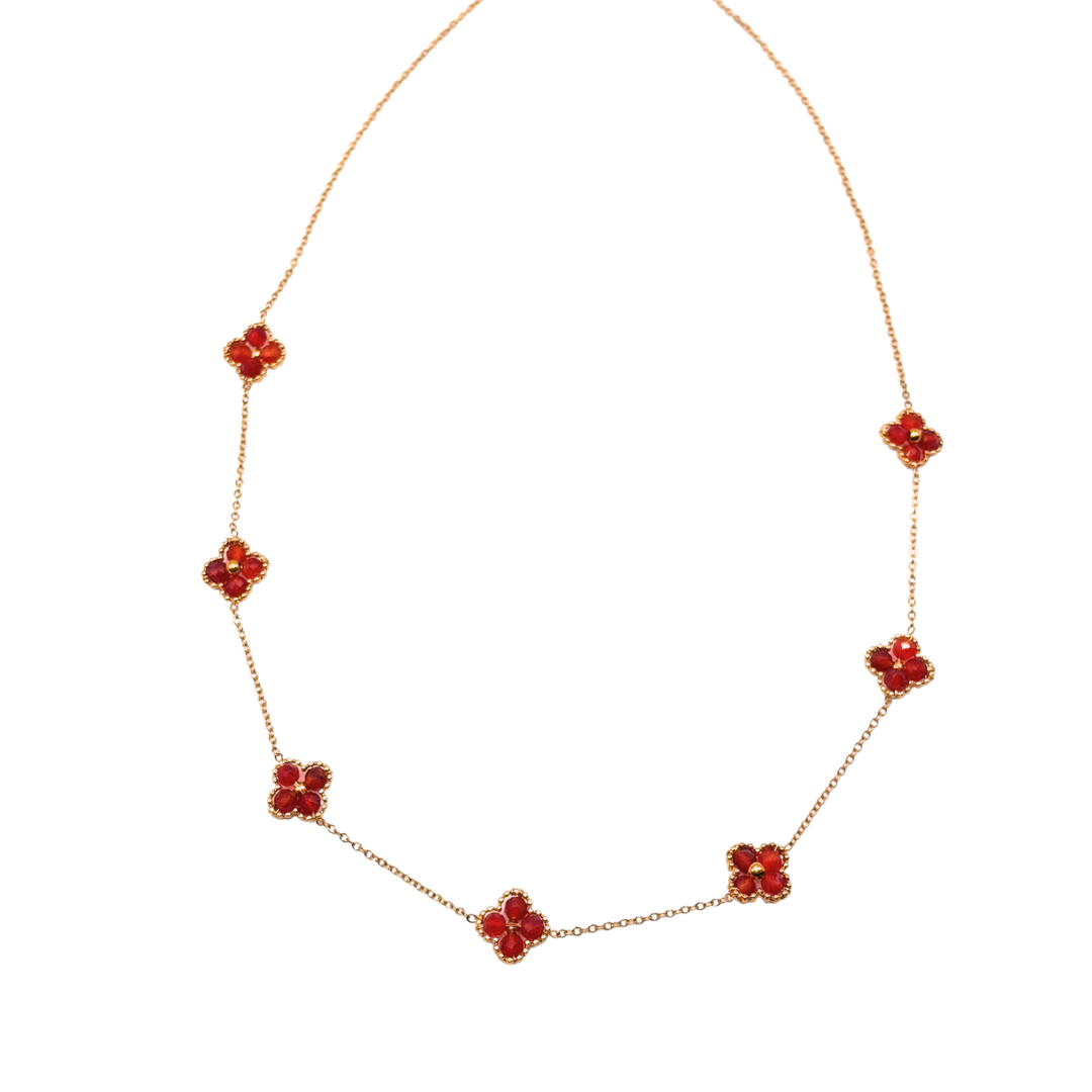 Collier minimaliste avec des pierres naturelles rouges montées sur une fine chaîne dorée.