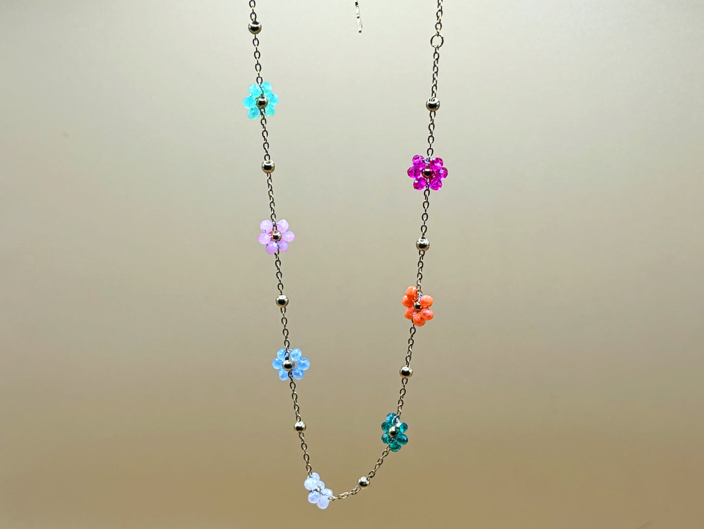 Collier délicat avec des fleurs en pierres naturelles, porté sur le cou pour un rendu élégant.