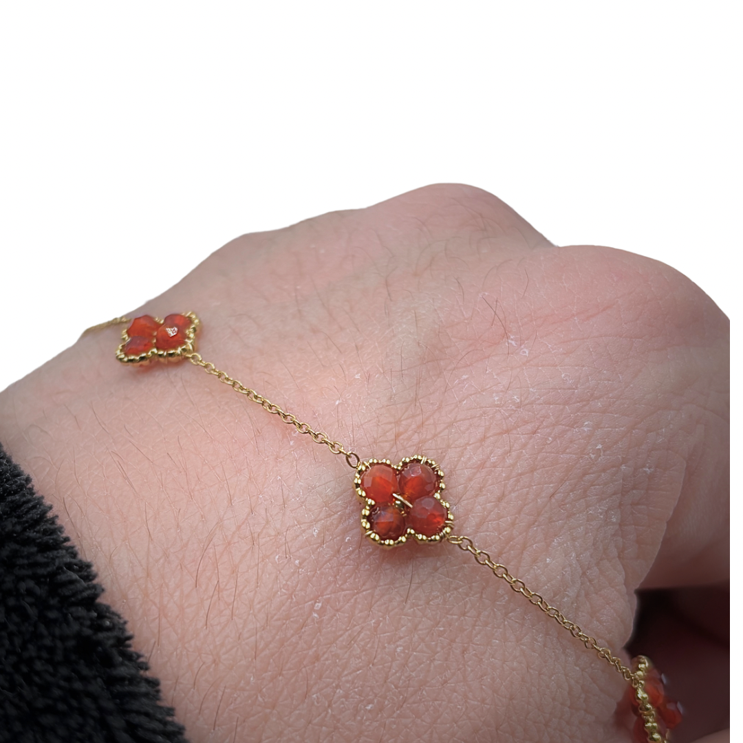 Vue détaillée d’un collier en acier inoxydable avec des fleurs en pierres naturelles rouges.