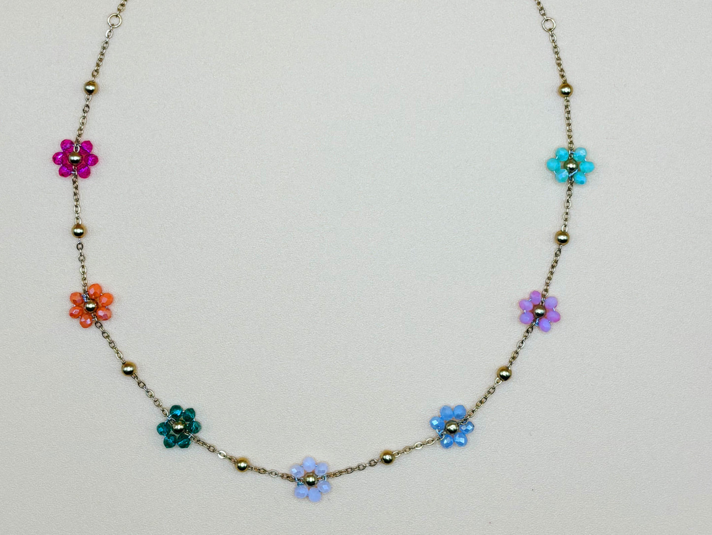 Gros plan sur les détails d’un collier floral en pierres naturelles et acier inoxydable 316L.