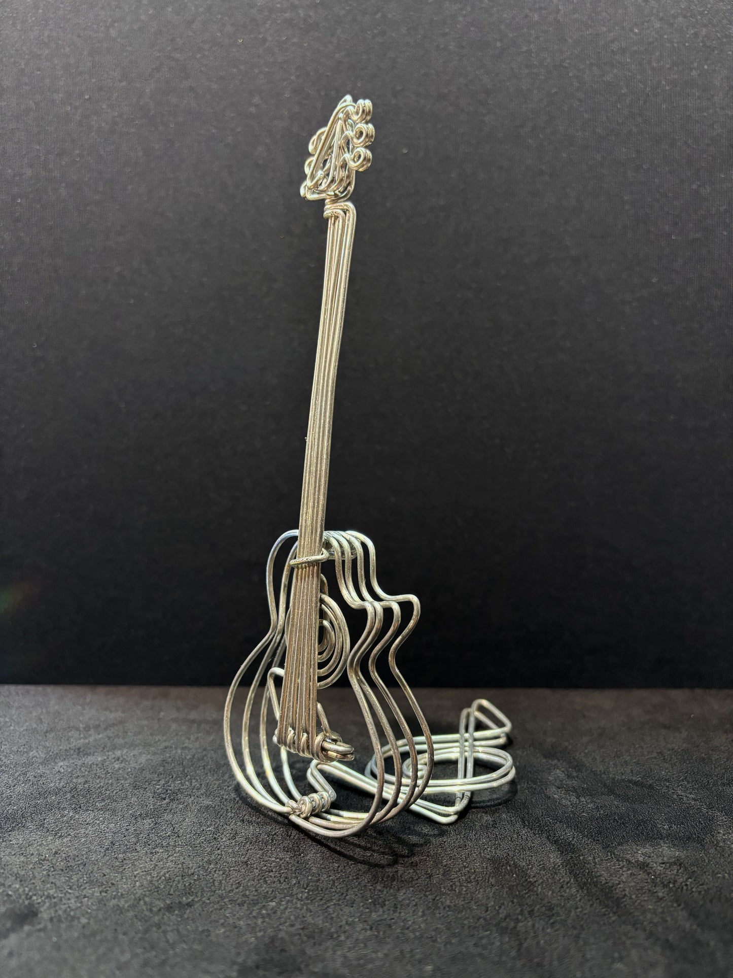 Sculpture de guitare en fil métallique, mettant en valeur les détails fins et le travail artisanal.