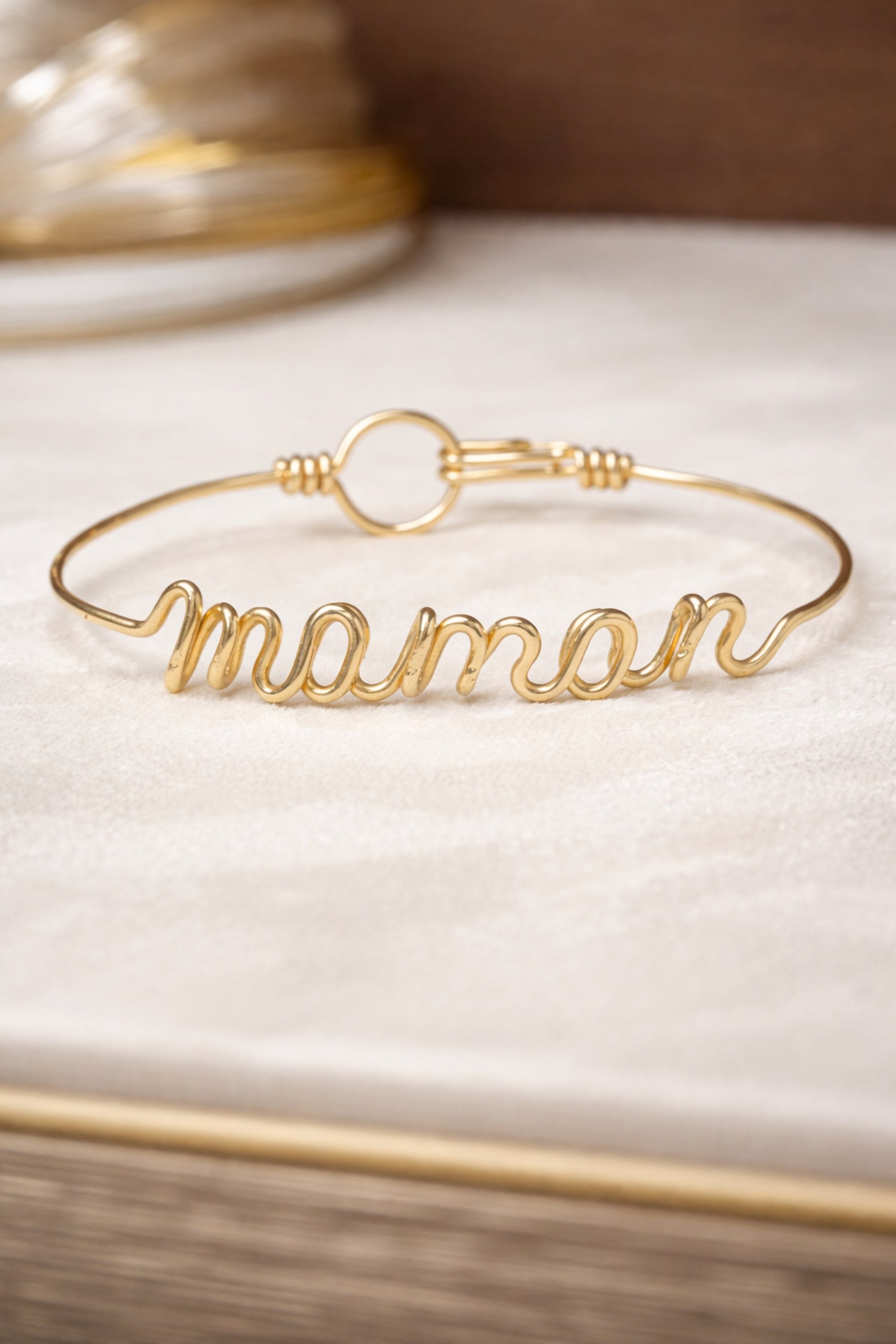 Bracelet prénom en fil doré formant le mot « maman »