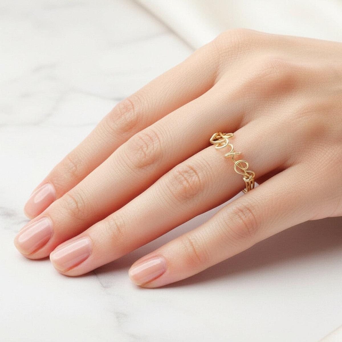 Bague en or personnalisée portée sur une main féminine, bijou élégant au style intemporel