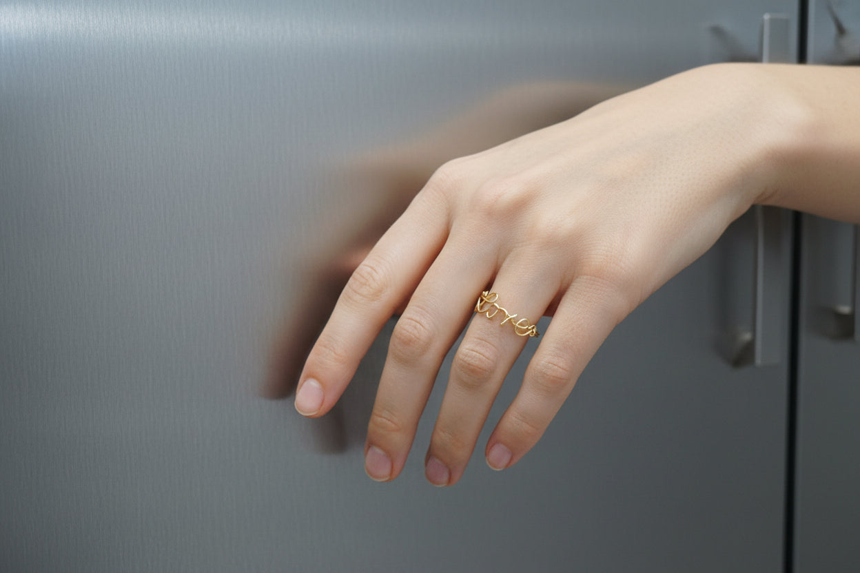 Détail d’une bague prénom personnalisée en fil doré, bijou fait main au design délicat.