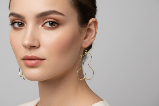 Boucles d’oreilles en fil doré portées par une femme élégante, bijou fait main au design fin et moderne.