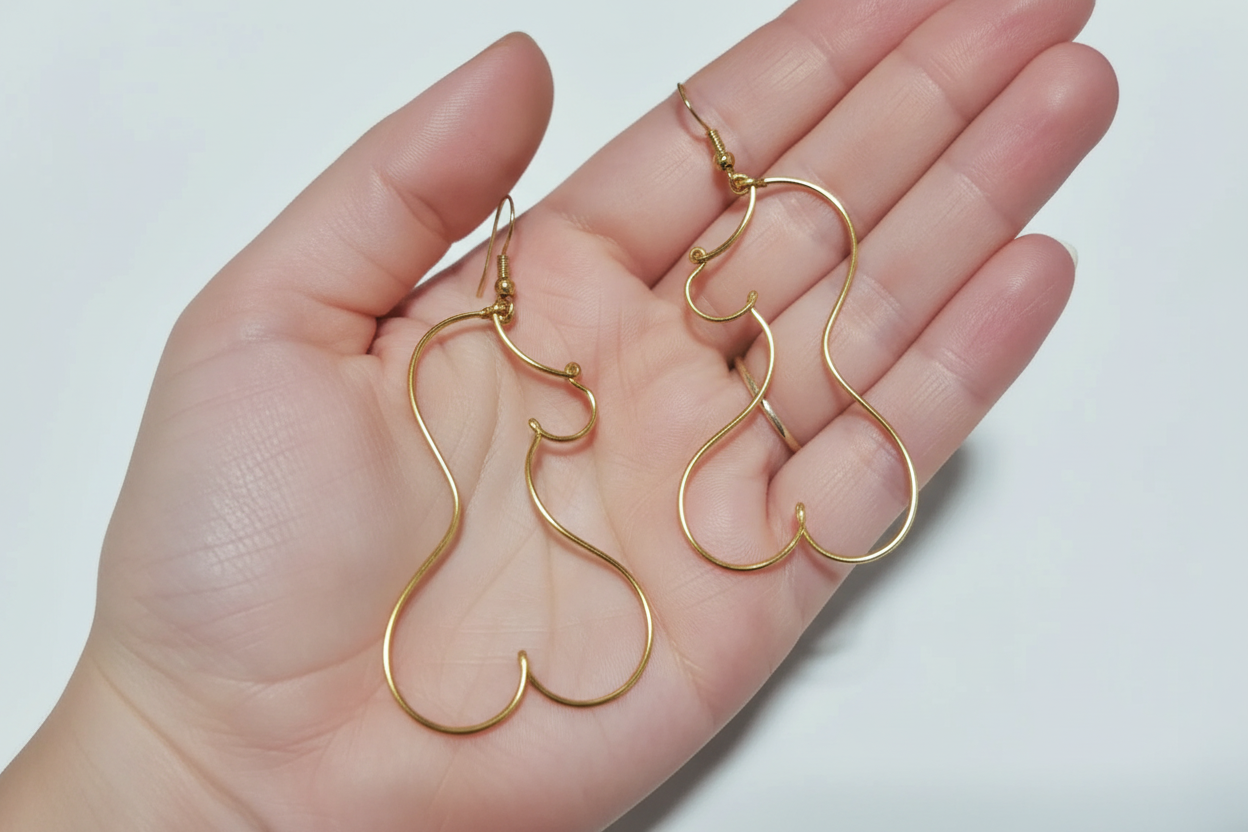 Boucles d’oreilles en fil doré tenues à la main, bijou fait main au design fin et élégant.
