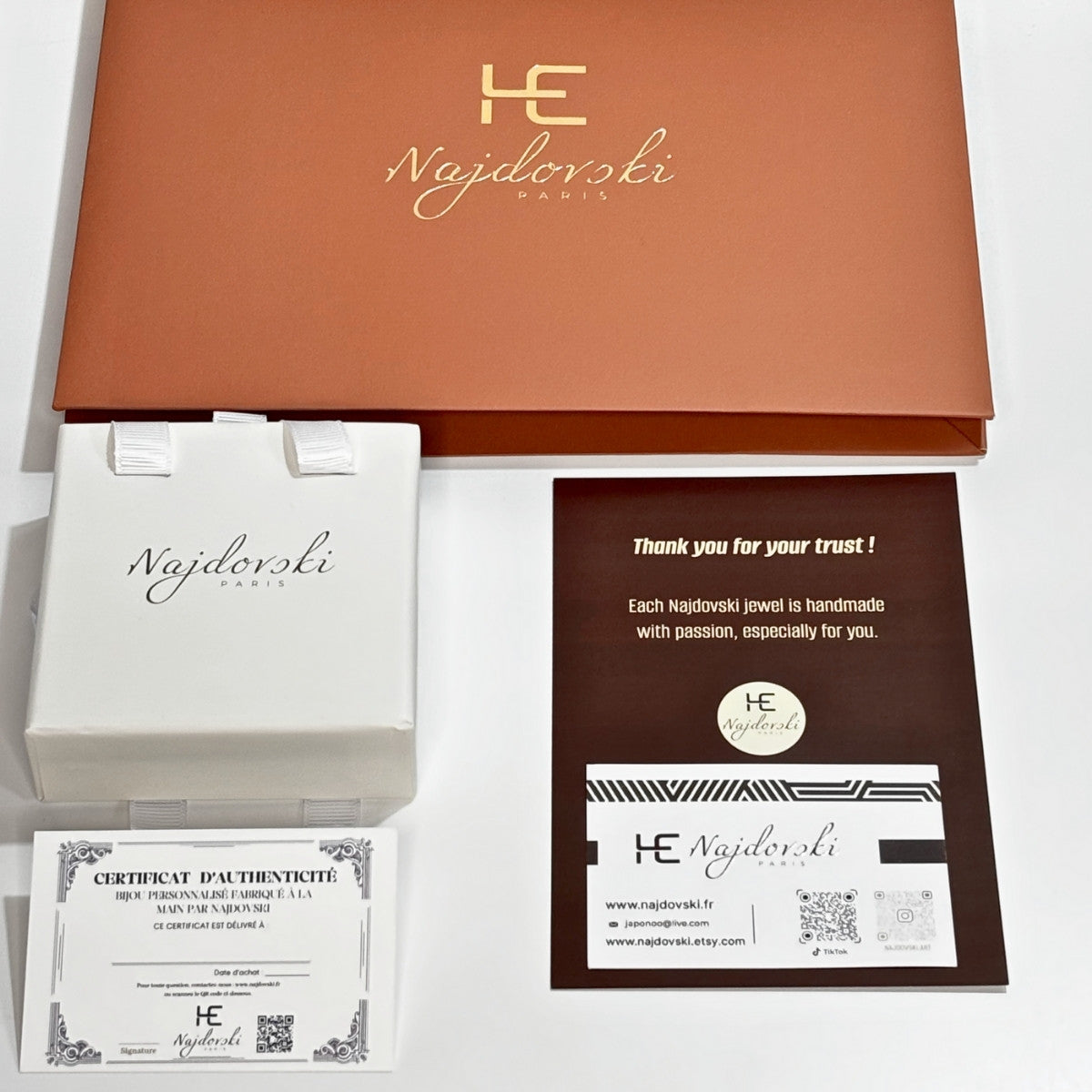 Packaging de bijoux comprenant une pochette, une boîte à bijoux, un certificat d’authenticité et une carte de visite